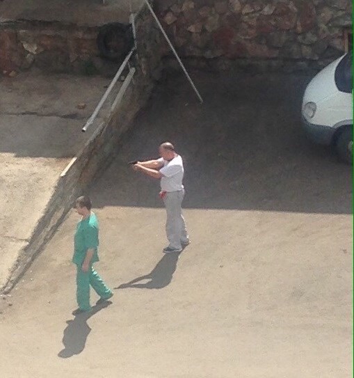 Очевидцы засняли мужчину с пистолетом на территории красноярской краевой больницы