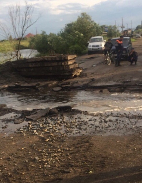 Жителей Канска после ливня переносили через разрытую дорогу в ковше экскаватора