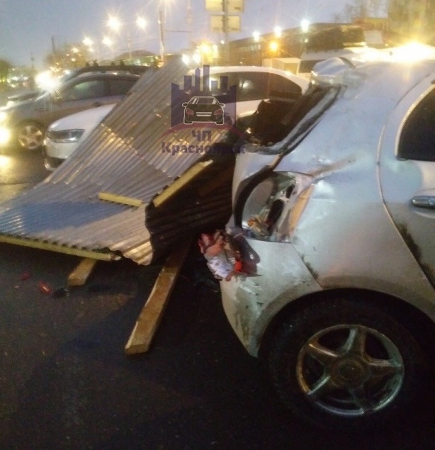 На правобережье Красноярска оторванная ветром крыша рухнула на автомобили